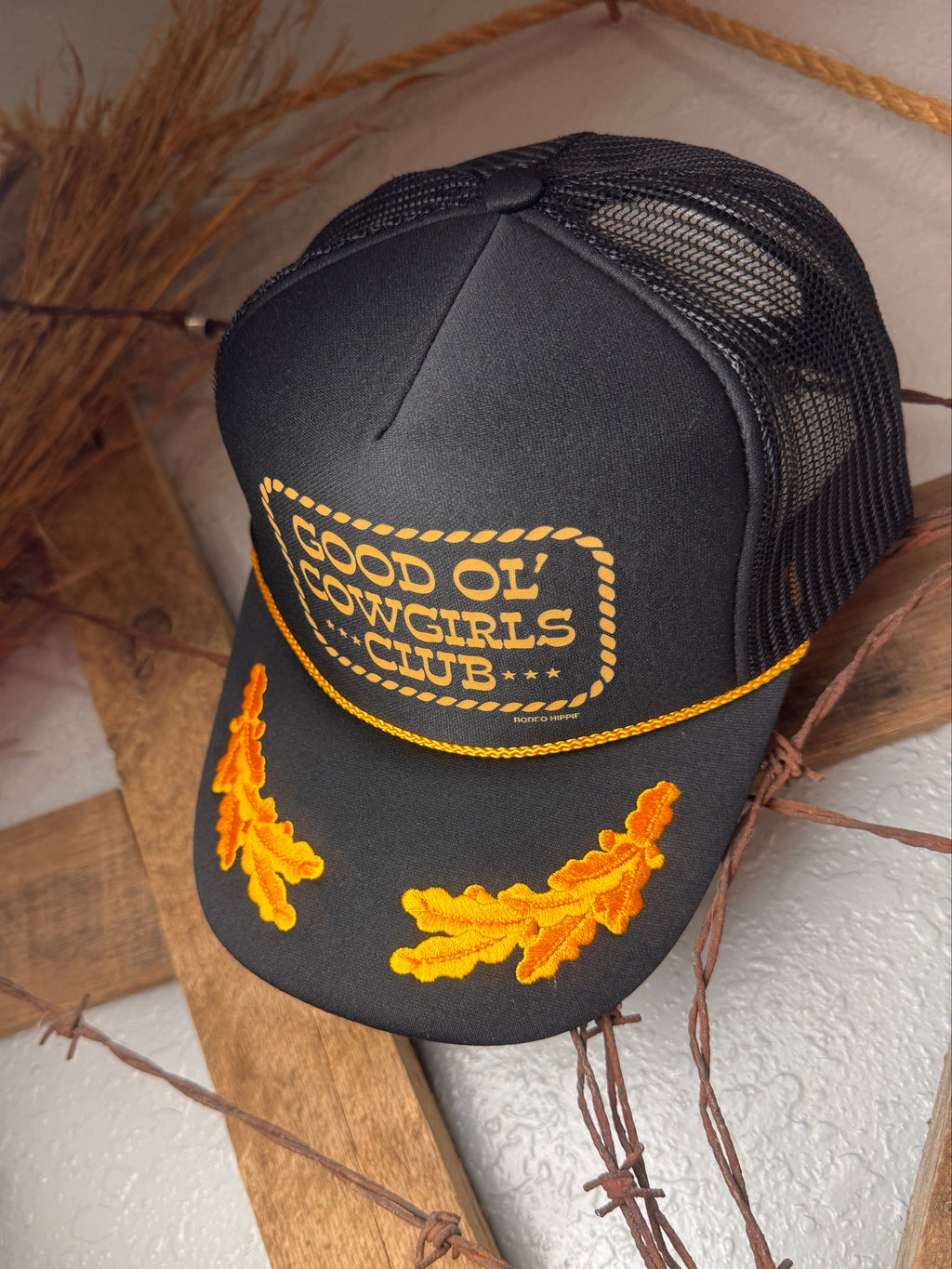 Black cap with yellow embroidery on a rustic background