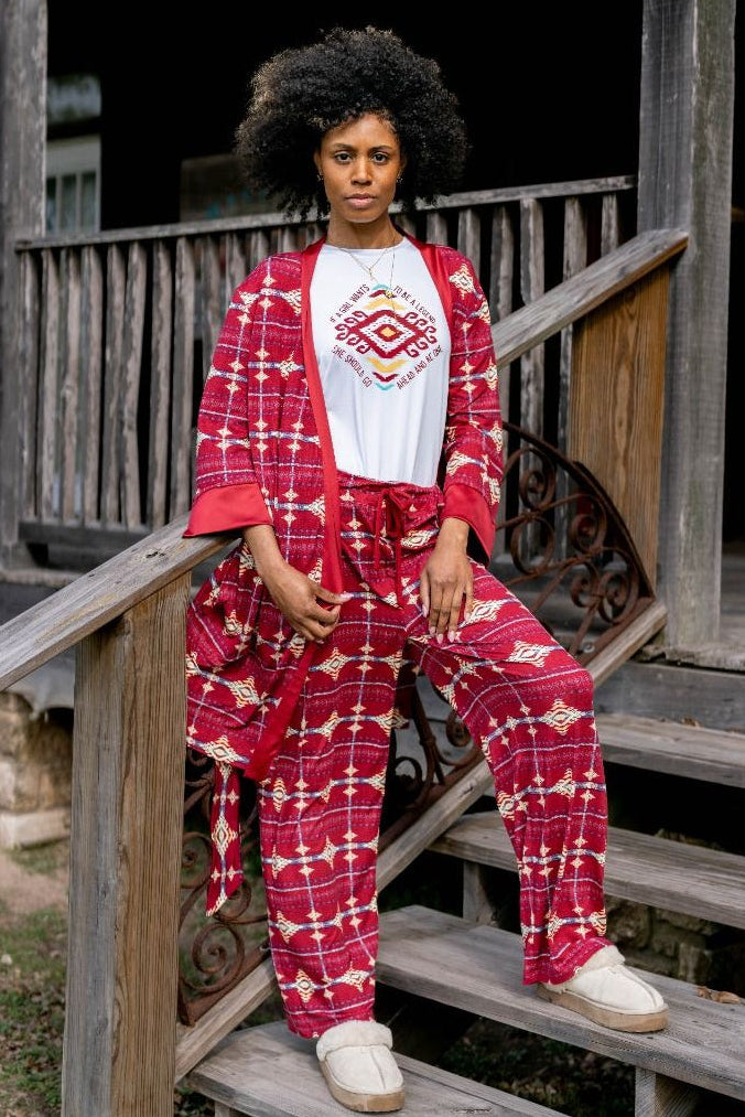 Person wearing a red patterned outfit sitting on wooden steps.
